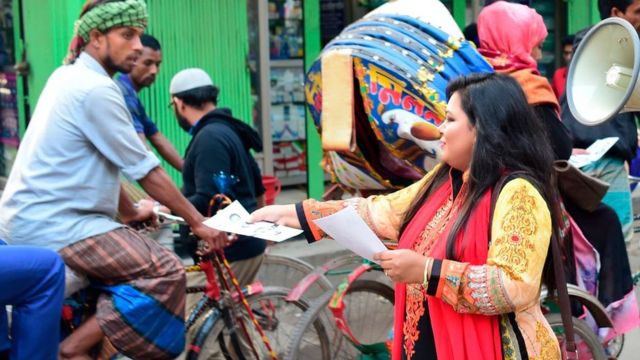ক্ষমতাসীন দলের এক প্রার্থীর পক্ষে লিফলেট বিলি করছেন একজন কর্মী।