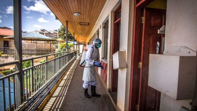 مسؤول صحي محلي يرتدي بدلة واقية ويعقم مركزا صحيا في نيروبي
