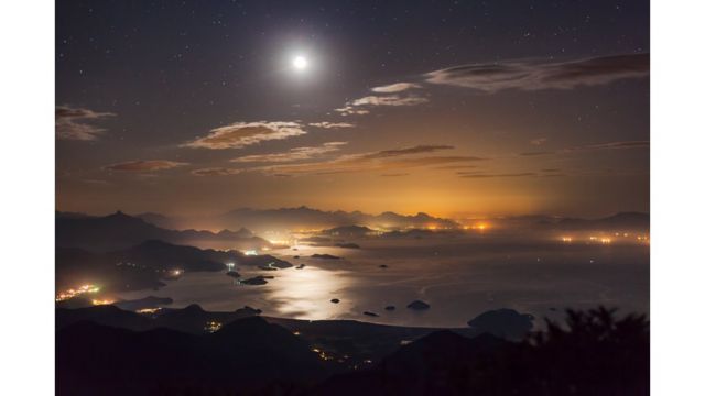 Луна освещает ночное небо над заливом Парати в Бразилии