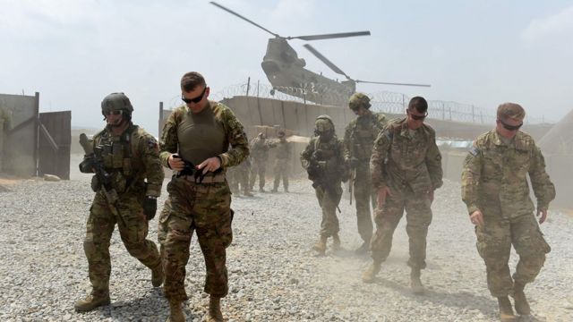 US soldiers walk by as a Nato helicopter flies overhead at a coalition base in the Khogyani district in the eastern Afghan province of Nangarhar. August 12, 2015