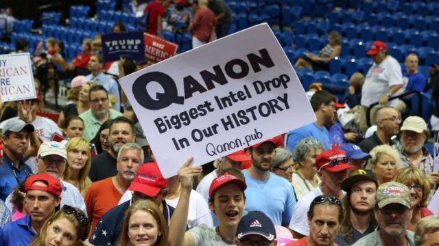 Apoiadores exibindo pôsteres do QAnon apareceram nos comícios de Trump no verão passado
