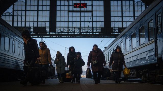 مجموعة من اللاجئين تسير في محطة السكك الحديدية المركزية في مدينة لفيف، أوكرانيا في 22 مارس/آذار 2022