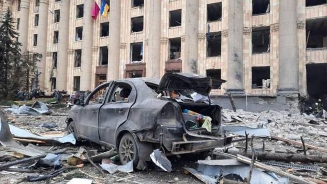 سيارة محترقة وسط حطام خلفه القصف الروسي لميدان الحرية في خاركيف.