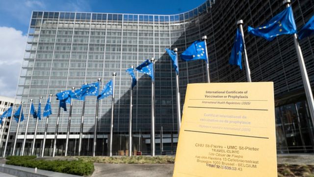 Сертификат о вакцинации на фоне здания ЕС в Борюсселе