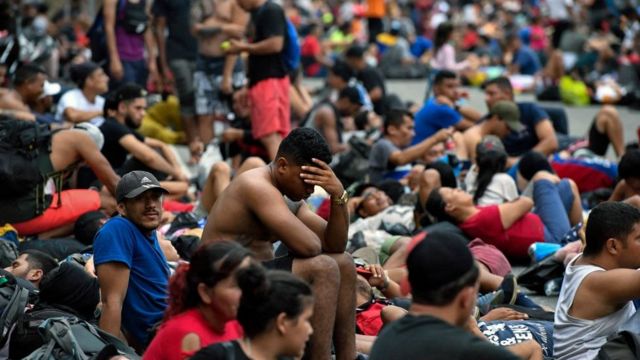 Migrants wait to enter US territory.