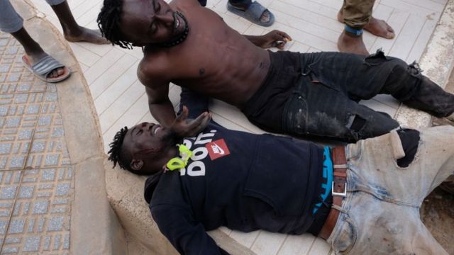Dos migrantes tras haber cruzado la valla de Melilla.