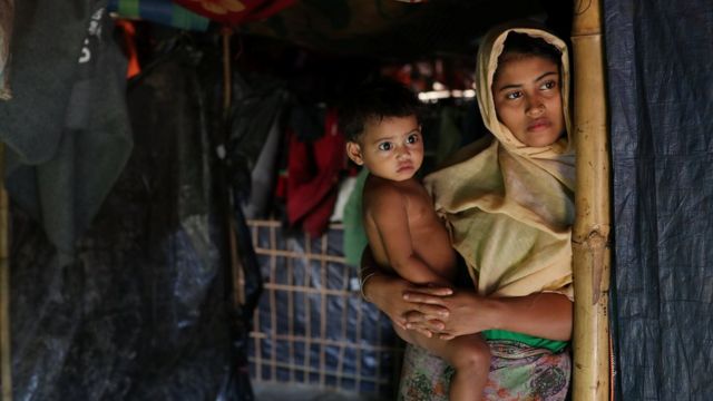Женщина-рохинья с ребенком на руках в укрытии в Бангладеш