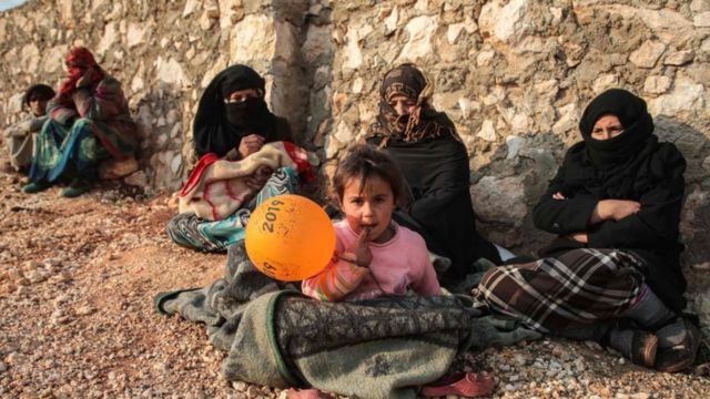 Displaced Syrians from Idlib province sit out in the open in the countryside