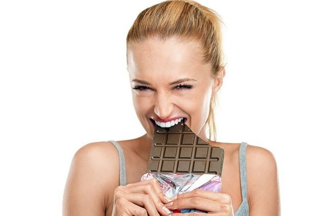 امرأة تتناول الشوكولاته بسعادة