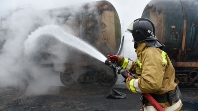 Пожарный тушит железнодорожную цистерну