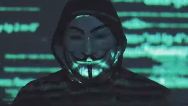 A man in a Guy Fawkes mask appears in this image taken from a Facebook video