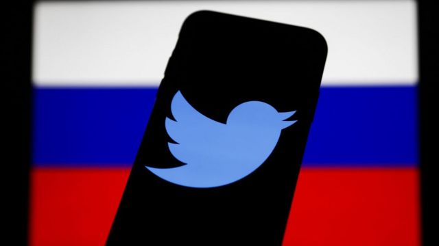 شعار موقع تويتر أمام علم روسيا