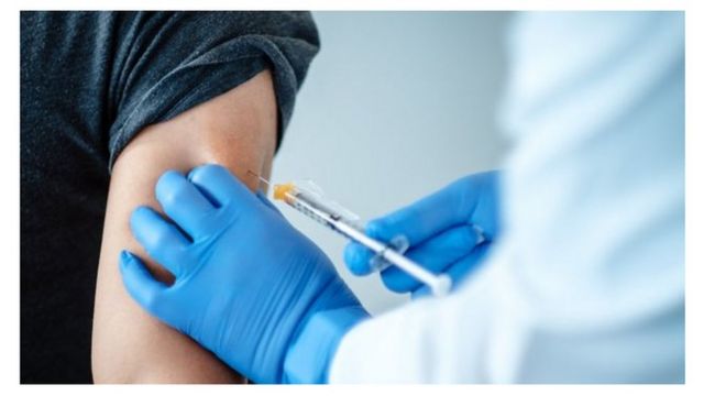 A medical worker gives the vaccine to a person.