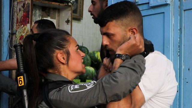 مواجهة بين متظاهر فلسطيني وجندية من أفراد الأمن الإسرائيلي.