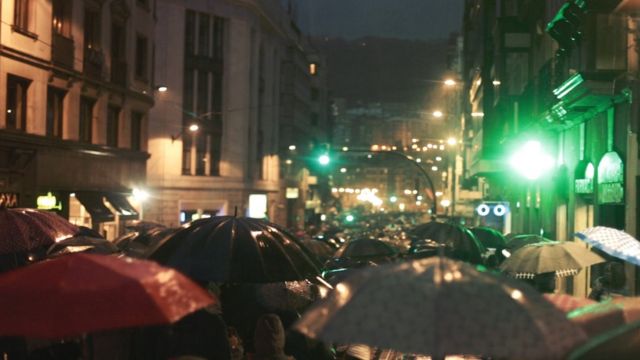 Habitantes del País Vasco caminan con paraguas.
