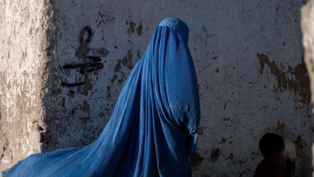 An Afghan woman wears a blue burqa
