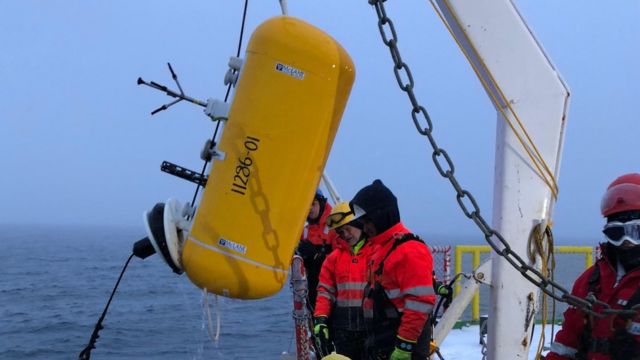 Cientistas extraem uma âncora da água do Ártico com instrumentos que medem o fluxo de calor do interior do oceano para a superfície