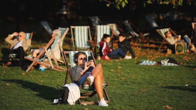 parkta güneşlenen insanlar