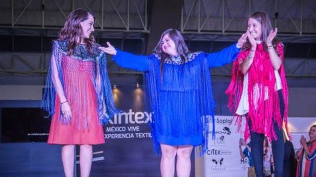 Isabella on stage with two models, all in her clothes