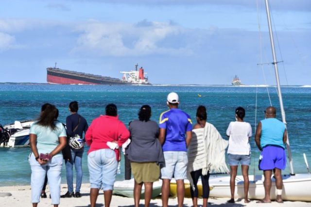 People on shore look out at the MV Wakashio on 6 August 2020.