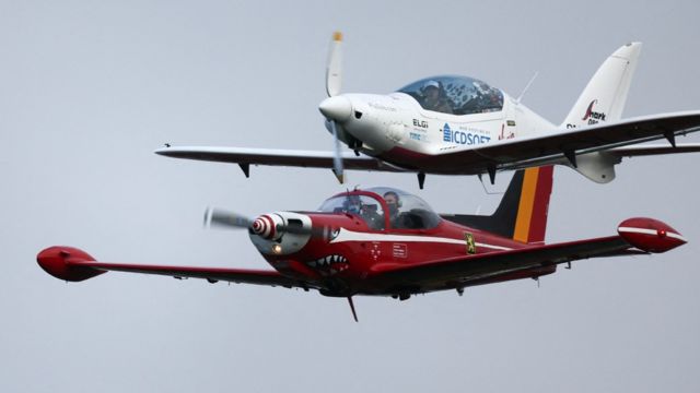 El avión deportivo ultraligero Shark UL acompañado por los Red Devils belgas antes de aterrizar.