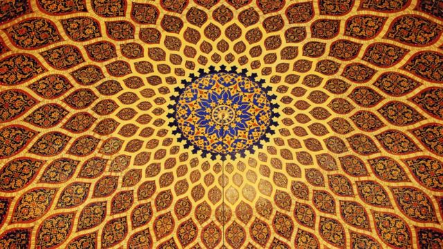 The ceiling of the mosque in the United Arab Emirates has geometric shapes in gold and bronze.
