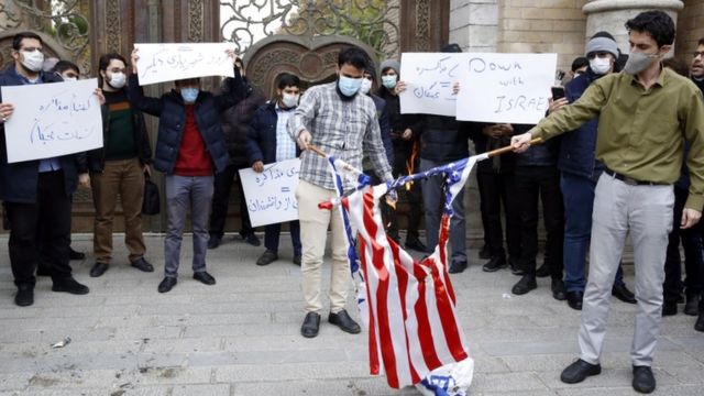 Students with masks and with signs that said 