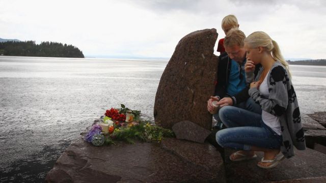 Personas rindiendo tributo a las víctimas cerca de la isla de Utøya.