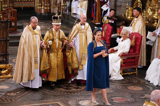 Camilla, Queen Consort looks on as Penny Mordaunt leads King Charles III wearing the St Edward's Crown