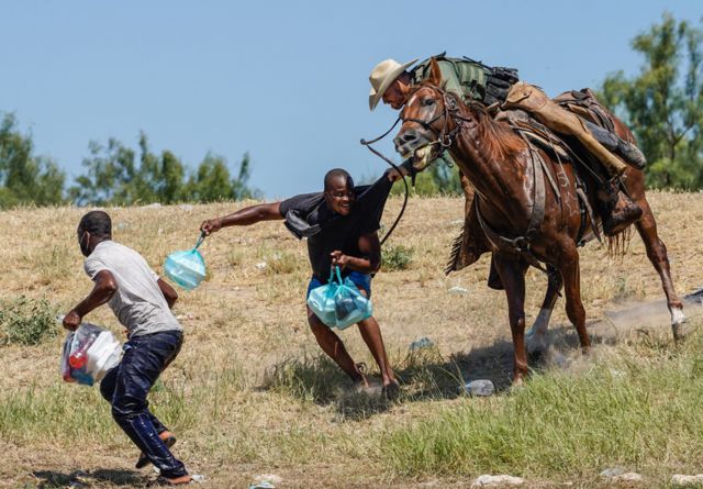 A United States Border Patrol agent on horseback tries to stop a Haitian migrant from entering an encampment on the banks of the Rio Grande near the Acuna Del Rio International Bridge in Del Rio, Texas