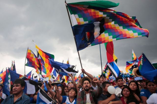 Bolivianos con la bandera indígena