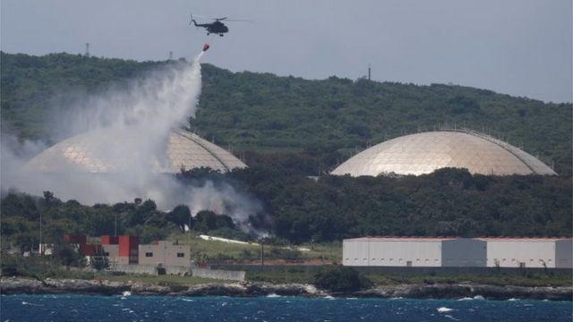 A helicopter drops water on a fire caused by lightning in a fuel tank in Madanzas, 130 km east of Havana.