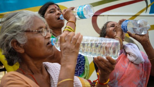 Mujeres en India beben agua durante una ola de calor.
