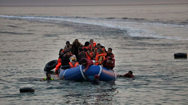 una barca llena de refugiados llega a la costa.