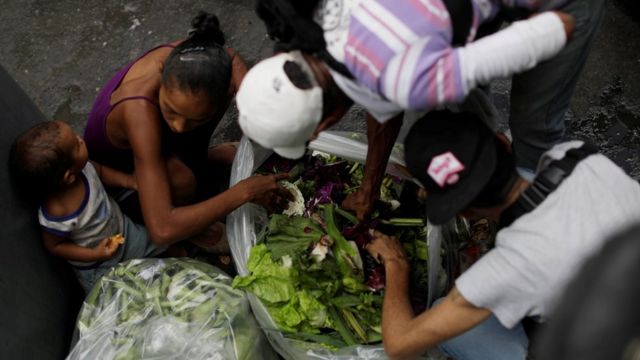 Personas en Venezuela buscan comida en la basura.