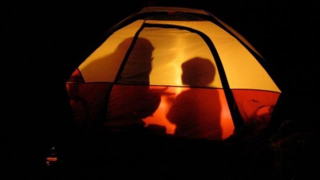 Sombras de madre e hijo acampando.