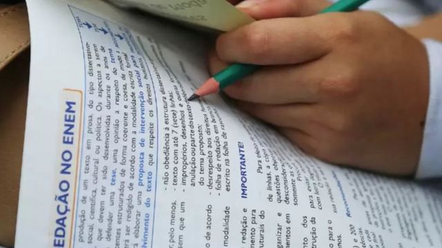 Mão de estudante fazendo prova do Enem