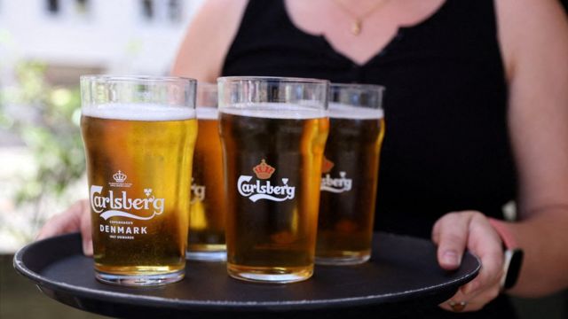 A bar worker carries a tray of Carlsberg beer in Copenhagen, Denmark.