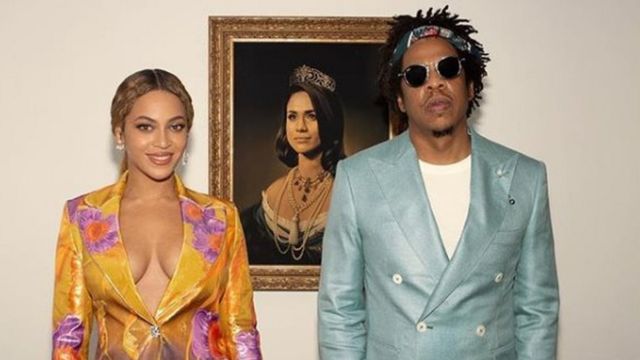 Image of Beyonce and Jay-Z in front of a portrait of Meghan Markle