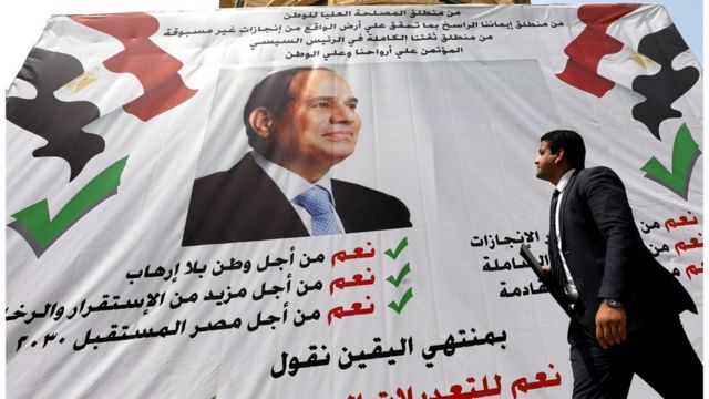 مصري يمر أمام لافتة لدعم السيسي