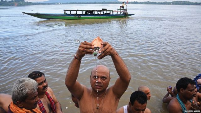 A Hindu man performs Tarpana, a religious ritual, on the banks of the river Brahmaputra to honour the souls of his departed ancestors during the auspicious day of Mahalaya in Guwahati.