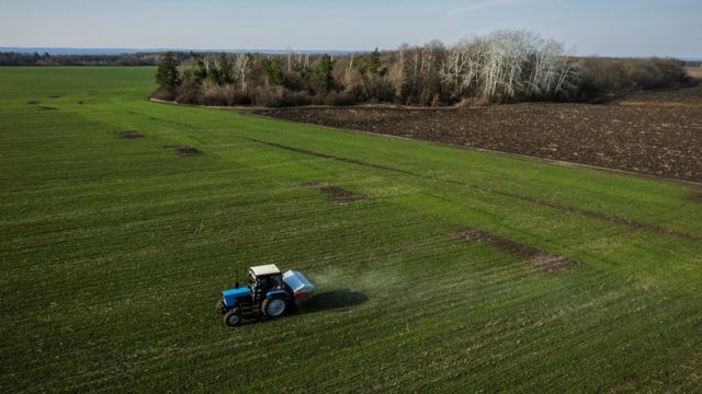 Farmers in the village of Yakovlevka near Kharkiv fertilize a wheat field on April 5, 2022