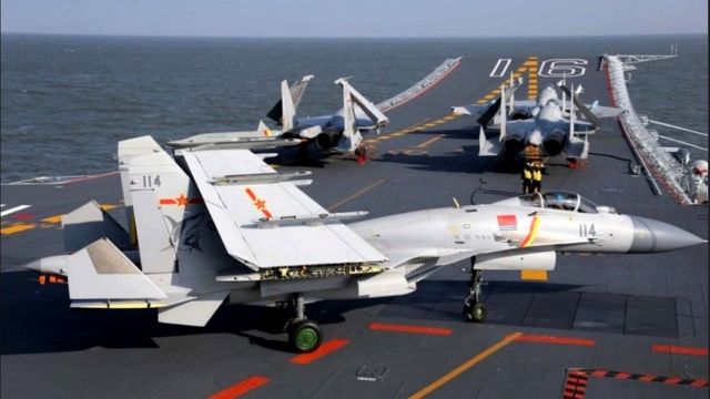 报道说中国正在建造使用直甲板和弹射技术的第二型国产航母。图为在中国造航母的滑跃甲板上的歼-15舰载机(photo:BBC)