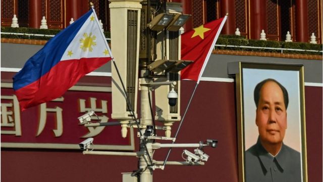 National flags of China and the Philippines and a portrait of Mao Zedong in front of the Tiananmen Gate in Beijing