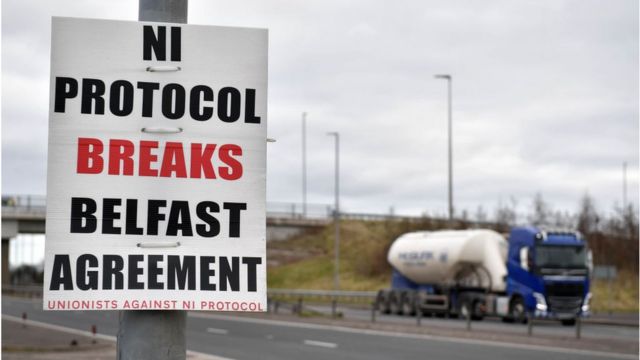 Un camión pasa junto a un cartel contra el Protocolo de Irlanda del Norte.