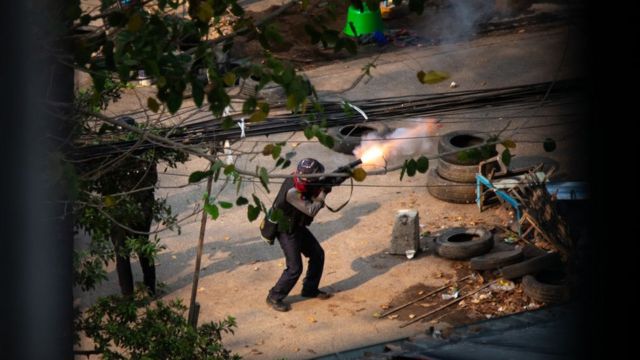 Полицейский стреляет по протестующим из 38-мм гранатомета