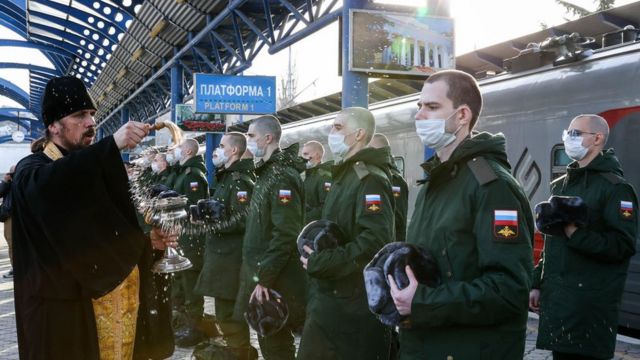 Православный священник благословляет российских призывников, отправляющихся на воинскую службу в Севастополе