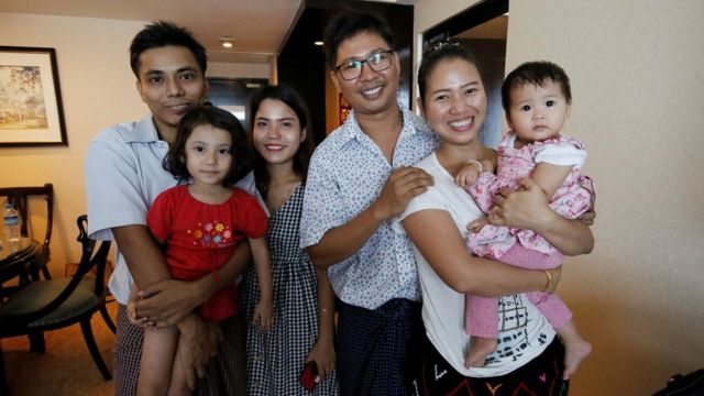 Wa Lone poses with wife Pan Ei Mon and daughter, along with Reuters reporter Kyaw Soe Oo carrying his daughter next to wife Chit Su Win,