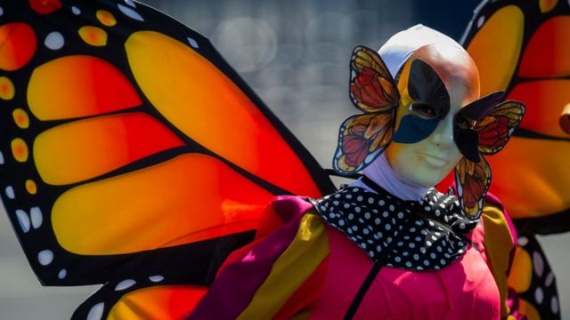 Una mujer disfrazada de mariposa en el desfile de Día de Muertos