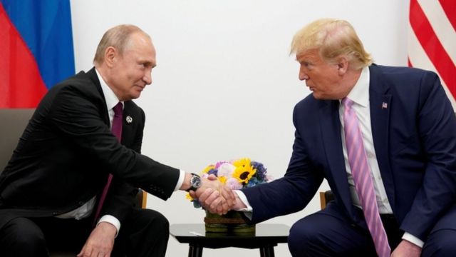 الرئيس الروسي فلاديمير بوتين والرئيس الأمريكي السابق دونالد ترامب يتصافحان